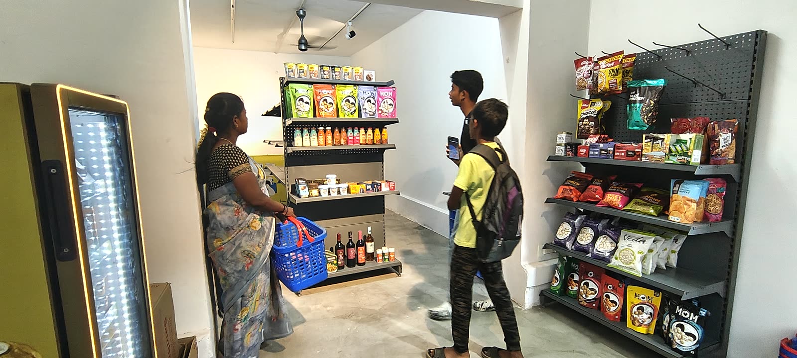 Customers shopping at stocked racks of protein snacks and healthy foods at a pop-up shop at IRL Space, NRT Nagar, Theni